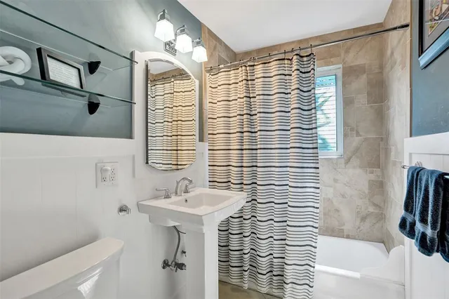 a bathroom with a sink a mirror and shower