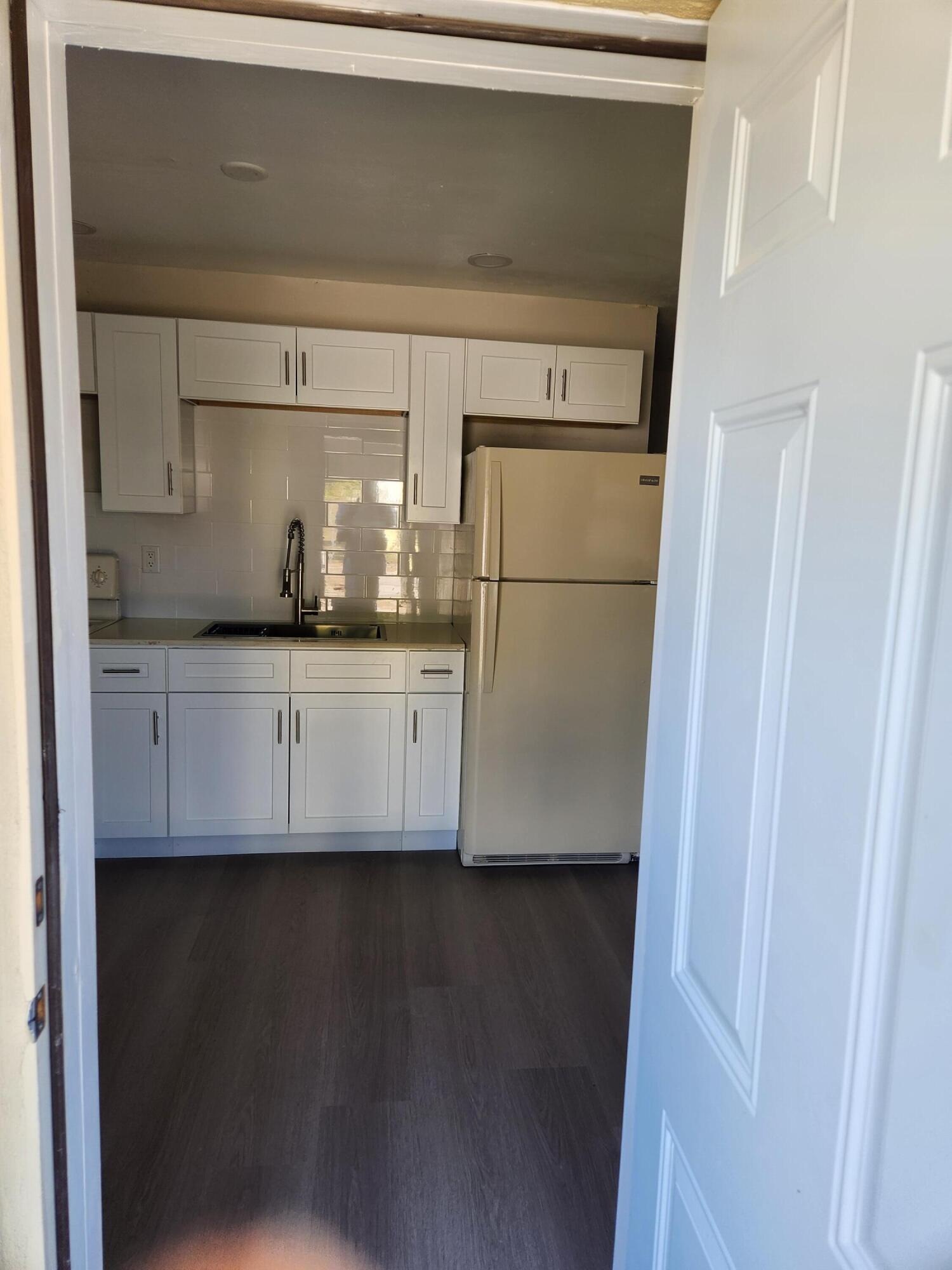 65 West 34th Street, Unit A Riviera Beach, FL 33404 - Photo 11 of 17 a kitchen with a sink and refrigerator