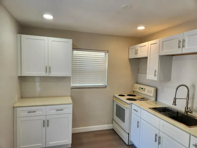 a kitchen with stainless steel appliances white cabinets and a stove top oven
