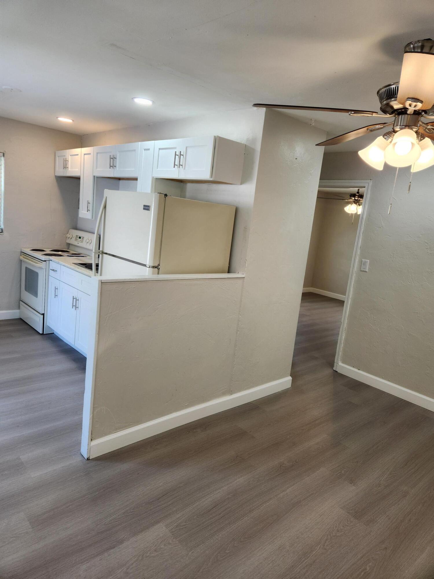 65 West 34th Street, Unit A Riviera Beach, FL 33404 - Photo 5 of 17 a view of a kitchen with wooden floor and electronic appliances