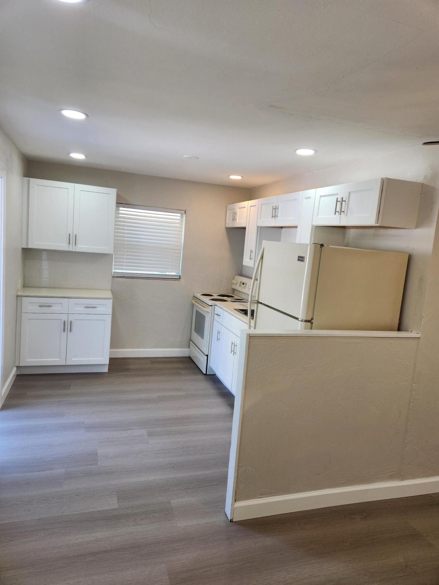 65 West 34th Street, Unit A Riviera Beach, FL 33404 - Photo 8 of 17 a view of a kitchen with wooden floor