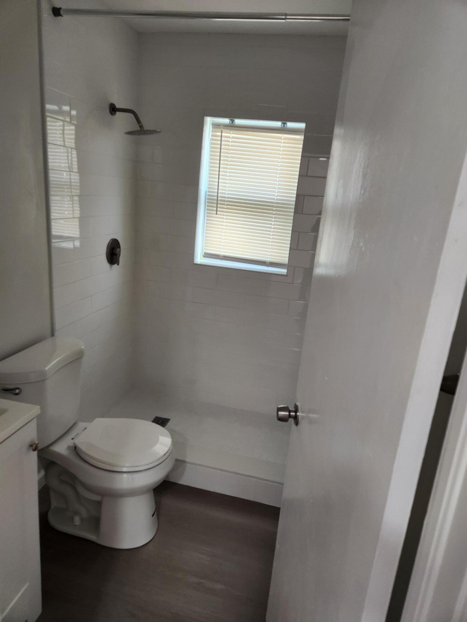 65 West 34th Street, Unit A Riviera Beach, FL 33404 - Photo 10 of 17 a white toilet sitting next to a bathroom sink