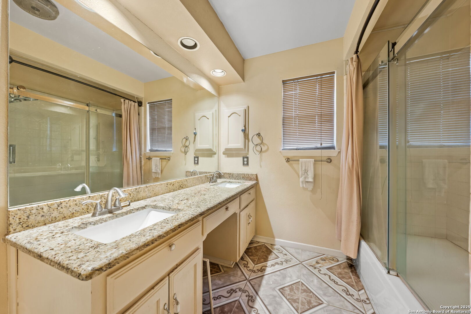 105 Golden Way Universal City, TX 78148 - Photo 20 of 23 a bathroom with a granite countertop sink a mirror and a shower