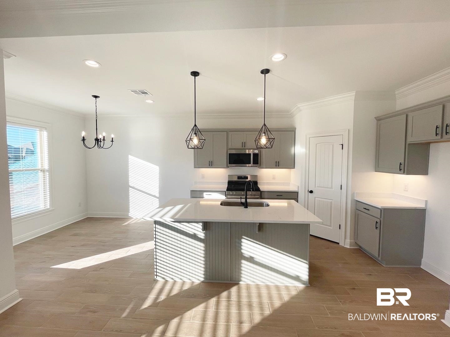 1403 Fenton Circle Foley, AL 36535 - Photo 2 of 15 Kitchen with gray cabinets, crown molding, light hardwood / wood-style floors, and an island with sink