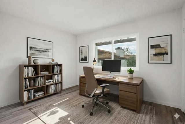 a view of a workspace with furniture and bookshelf