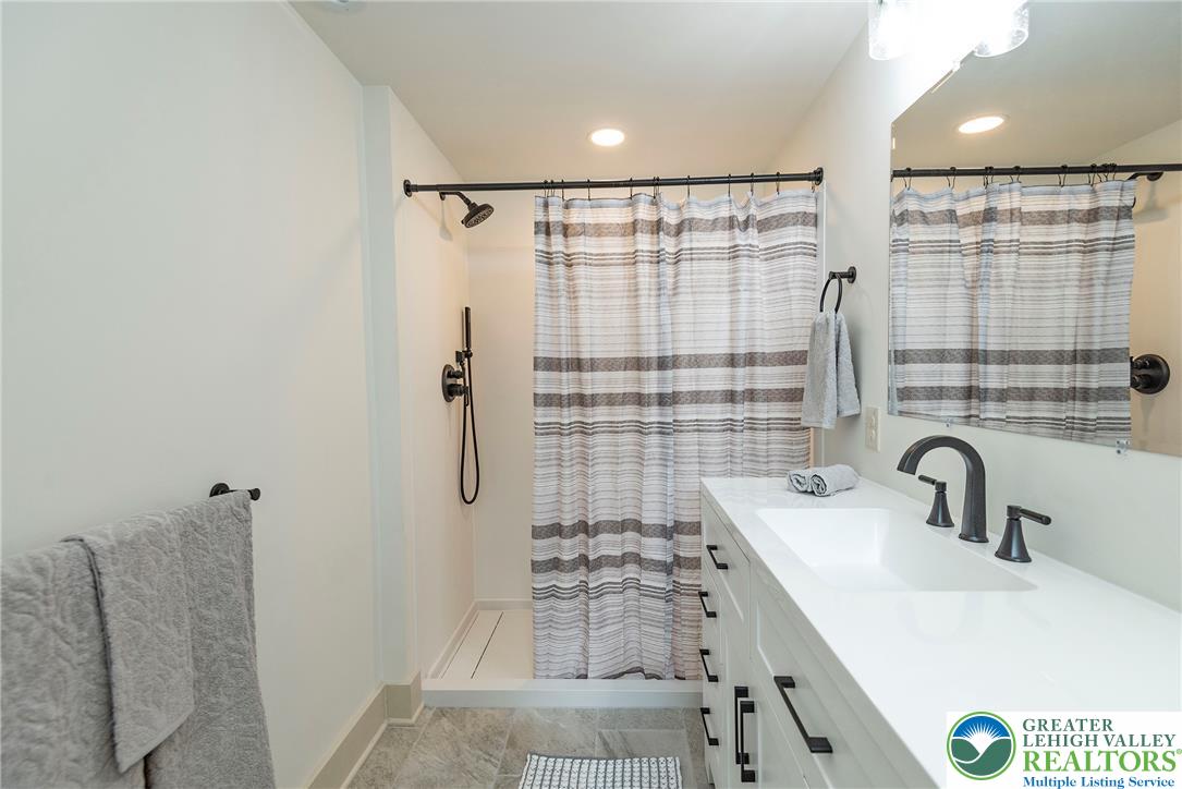 72 Allegheny Road Mount Bethel, PA 18343 - Photo 26 of 72 A well-lit bathroom boasts a sleek vanity and a shower with contemporary fixtures.