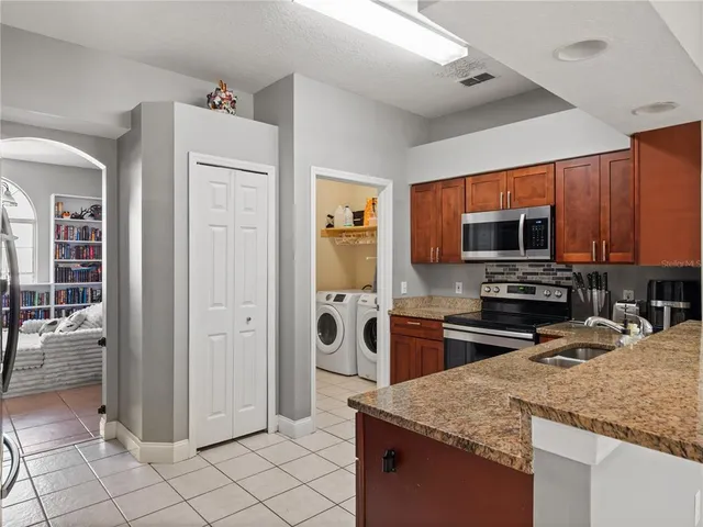 a kitchen with stainless steel appliances granite countertop a refrigerator and a sink