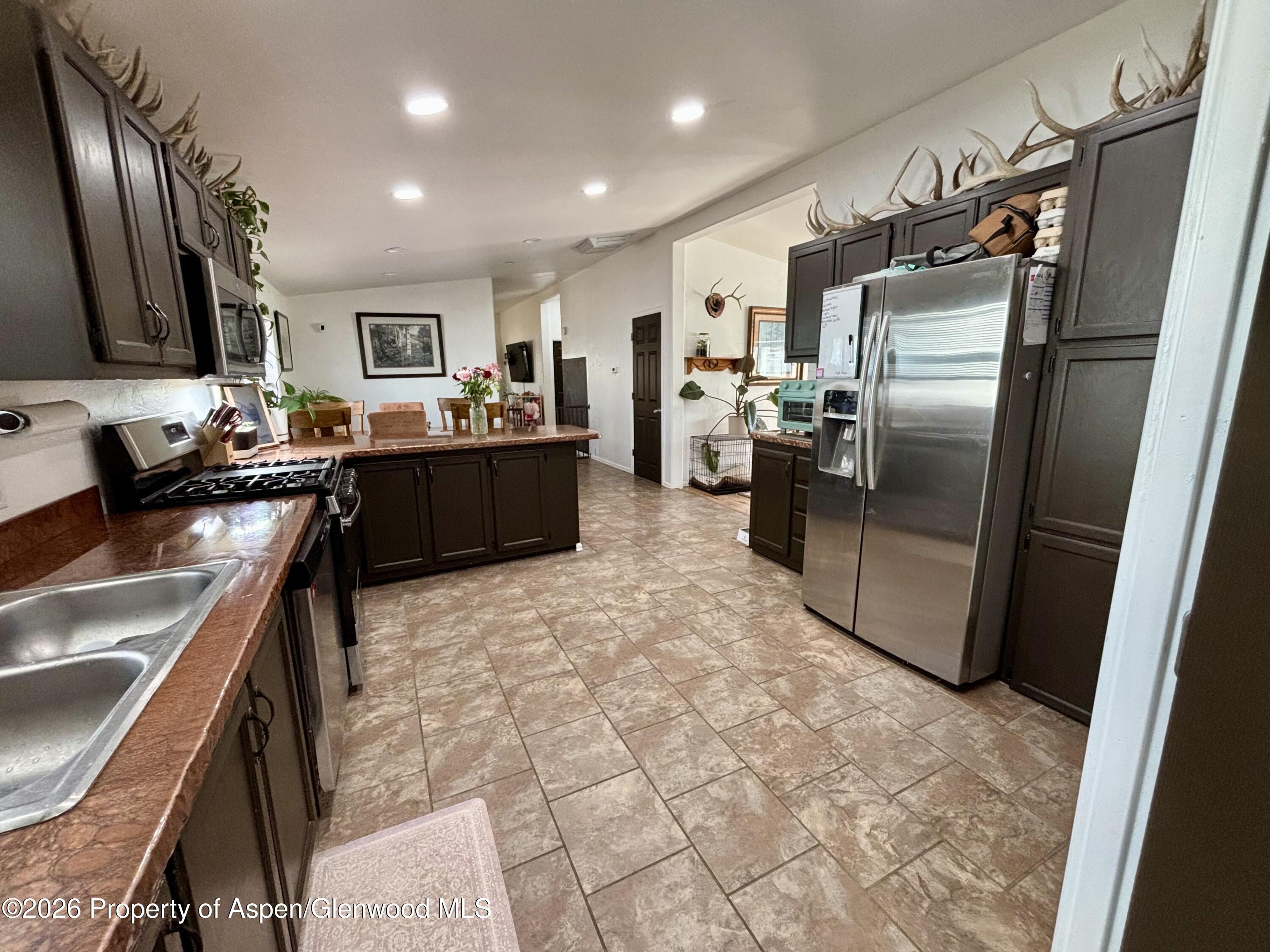 106 Cedar Circle Parachute, CO 81635 - Photo 10 of 35 a kitchen with stainless steel appliances granite countertop a refrigerator a sink a stove top oven and a refrigerator