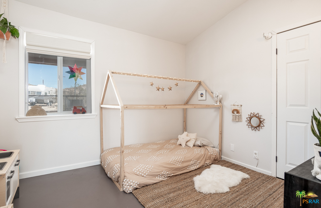 60525 Security Drive Joshua Tree, CA 92252 - Photo 21 of 39 a bedroom with a bed and wooden floor