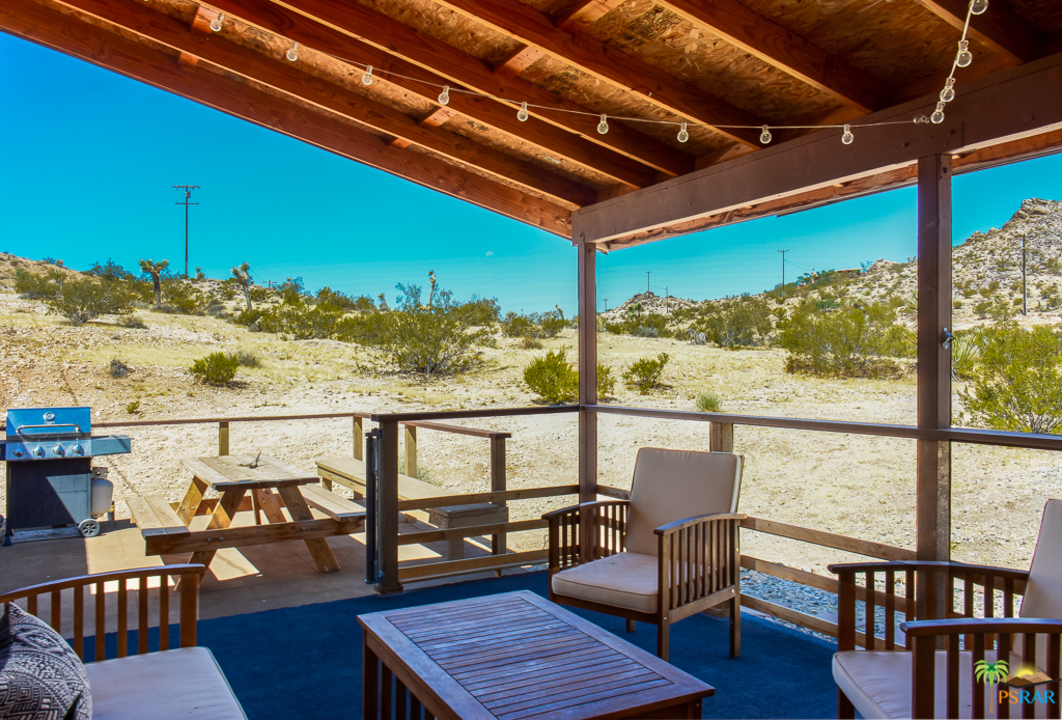 60525 Security Drive Joshua Tree, CA 92252 - Photo 28 of 39 a view of a balcony with chairs and wooden floor