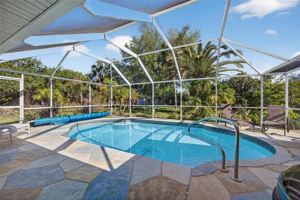 a view of a swimming pool with a patio and a yard