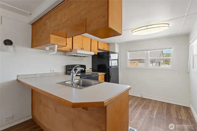 a kitchen with stainless steel appliances a sink a stove and a wooden floor
