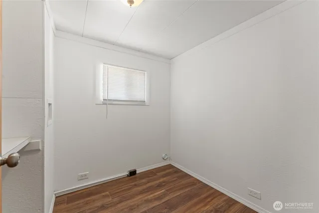 a view of a small space with wooden floor and a window
