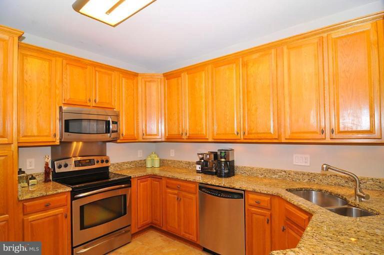 9404 Regency Crest Drive Vienna, VA 22181 - Photo 7 of 30 a kitchen with granite countertop a sink stainless steel appliances and cabinets