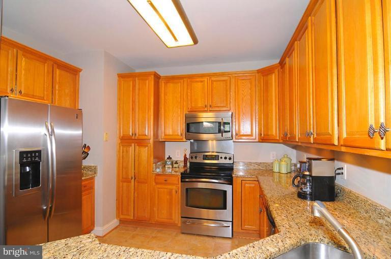 9404 Regency Crest Drive Vienna, VA 22181 - Photo 8 of 30 a kitchen with stainless steel appliances granite countertop a stove a sink and a refrigerator