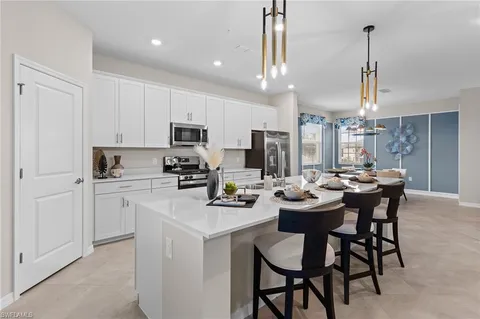 a large kitchen with stainless steel appliances kitchen island granite countertop a refrigerator a stove a sink and a refrigerator