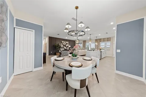 a dining room with wooden floor a chandelier a wooden table and chairs
