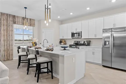 a kitchen with kitchen island granite countertop a table chairs microwave and cabinets