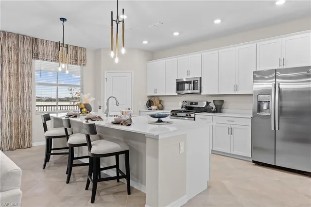 a kitchen with kitchen island granite countertop a table chairs microwave and cabinets
