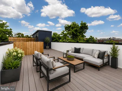 a roof deck with couch and a potted plant