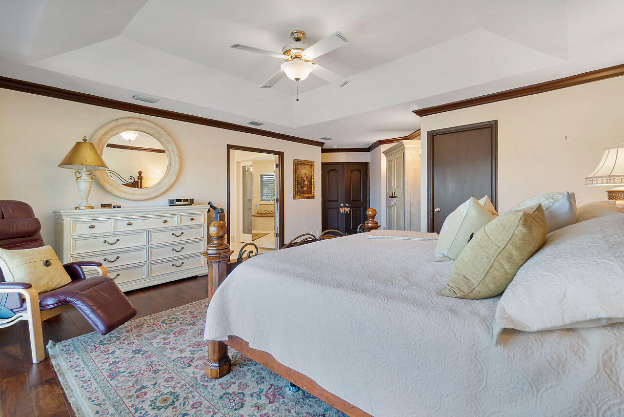4407 Woodfield Boulevard Boca Raton, FL 33434 - Photo 17 of 37 a spacious bedroom with a bed and closet with mirror