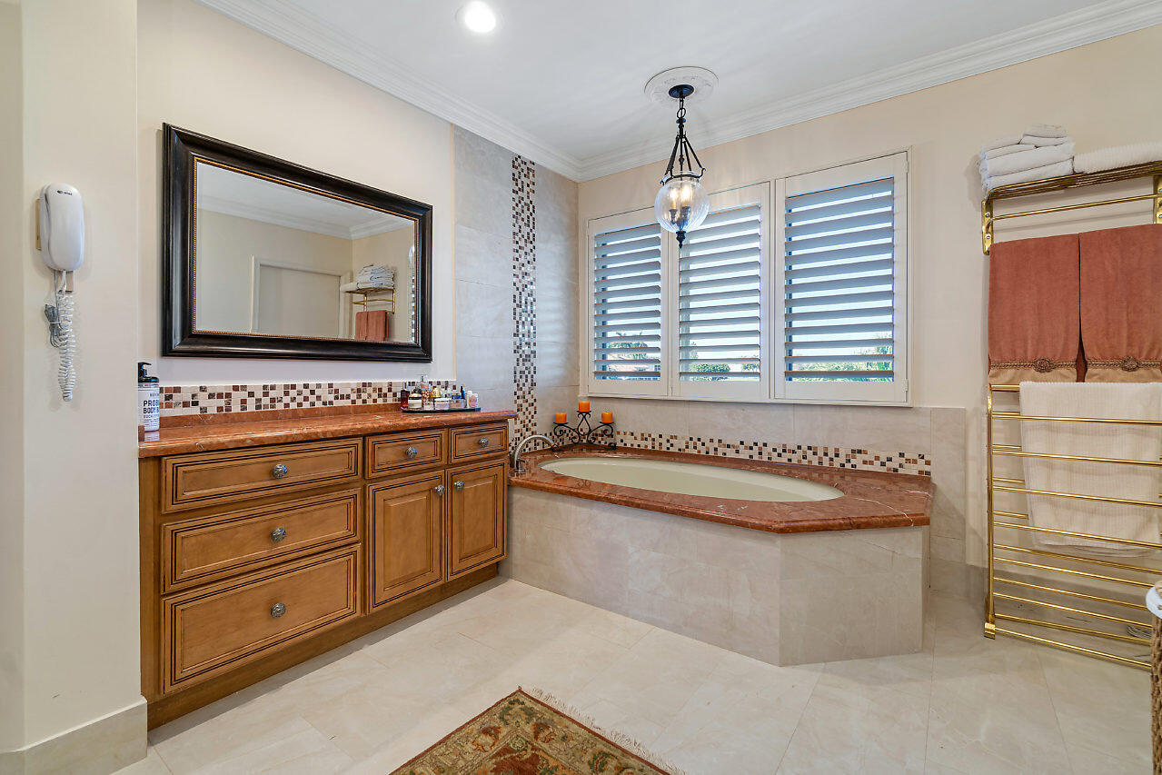4407 Woodfield Boulevard Boca Raton, FL 33434 - Photo 18 of 37 a bathroom with a bathtub and a sink