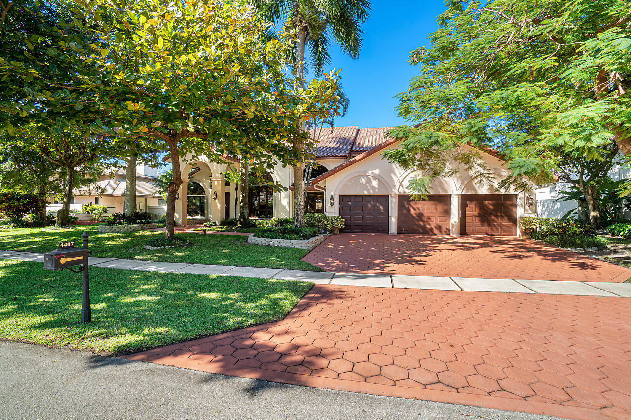 4407 Woodfield Boulevard Boca Raton, FL 33434 - Photo 2 of 37 a front view of house with yard and green space