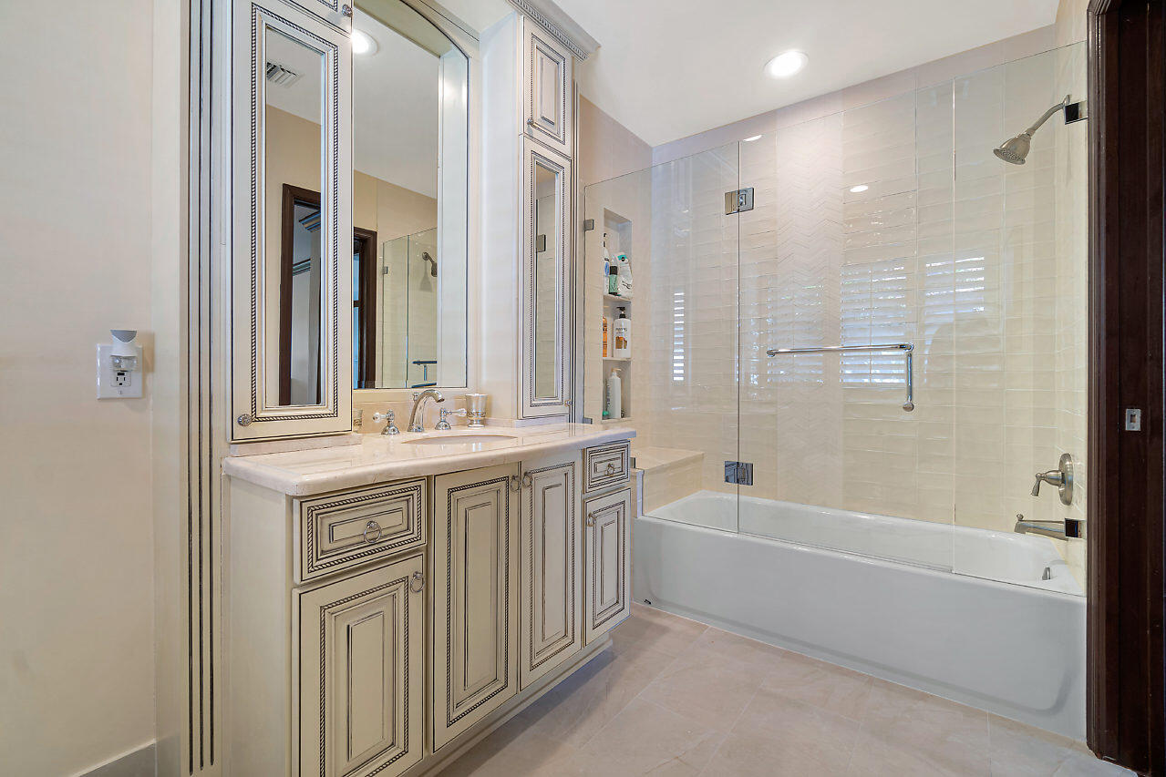 4407 Woodfield Boulevard Boca Raton, FL 33434 - Photo 25 of 37 a bathroom with a granite countertop sink a toilet and shower