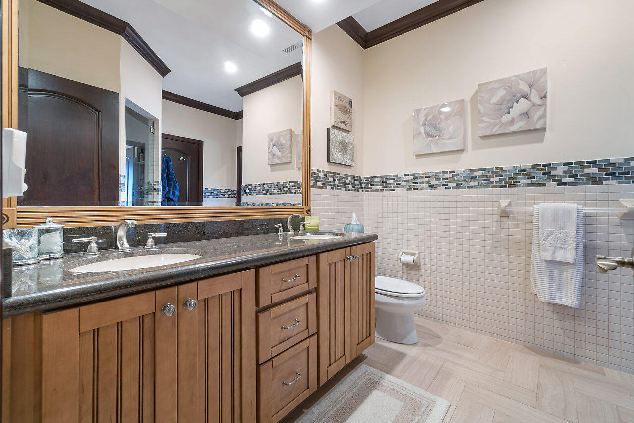 4407 Woodfield Boulevard Boca Raton, FL 33434 - Photo 27 of 37 a bathroom with a double vanity sink toilet and mirror
