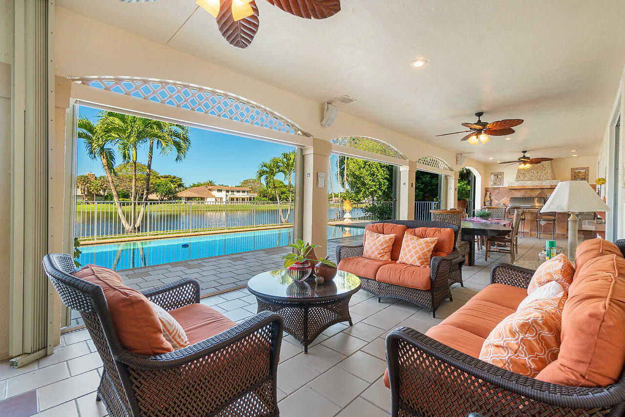 4407 Woodfield Boulevard Boca Raton, FL 33434 - Photo 32 of 37 a living room with patio furniture and a floor to ceiling window
