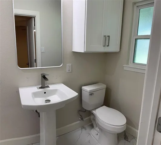 a white toilet sitting next to a bathroom sink