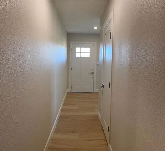 a view of a hallway with wooden floor and closet