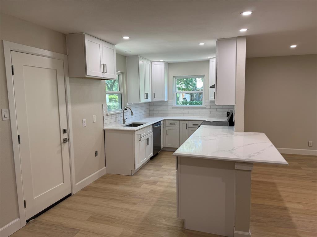 504 Pecan Street Crowley, TX 76036 - Photo 4 of 18 Kitchen featuring decorative backsplash, a peninsula, light wood-style floors, white cabinets, and recessed lighting