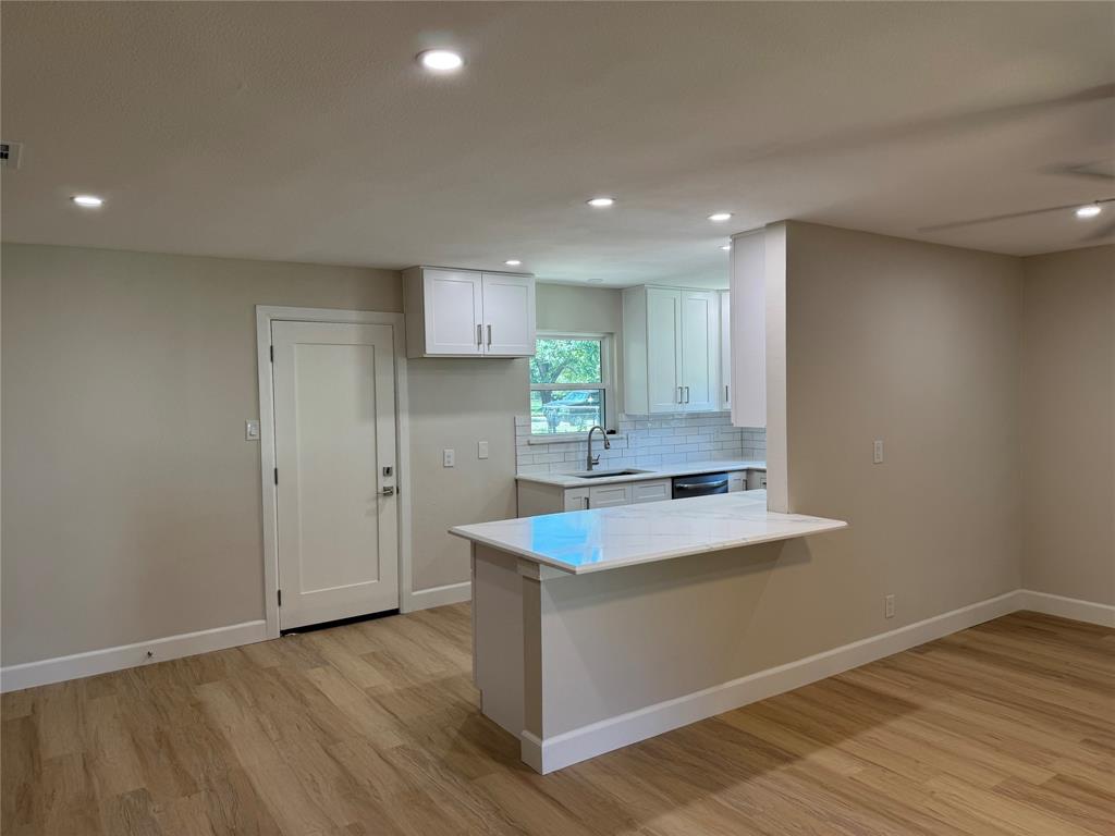 504 Pecan Street Crowley, TX 76036 - Photo 5 of 18 Kitchen featuring light countertops, tasteful backsplash, recessed lighting, light wood-style floors, and white cabinetry