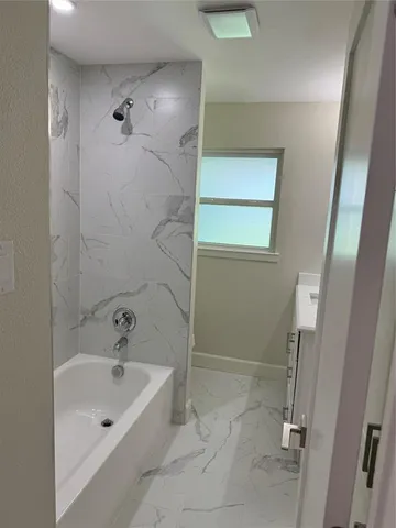 a bathroom with a tub and shower