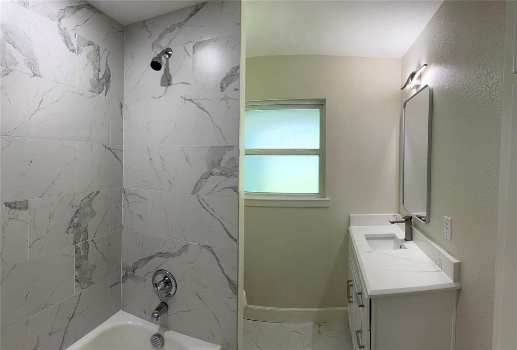 504 Pecan Street Crowley, TX 76036 - Photo 9 of 18 Bathroom featuring tub / shower combination, marble look tiles, and vanity