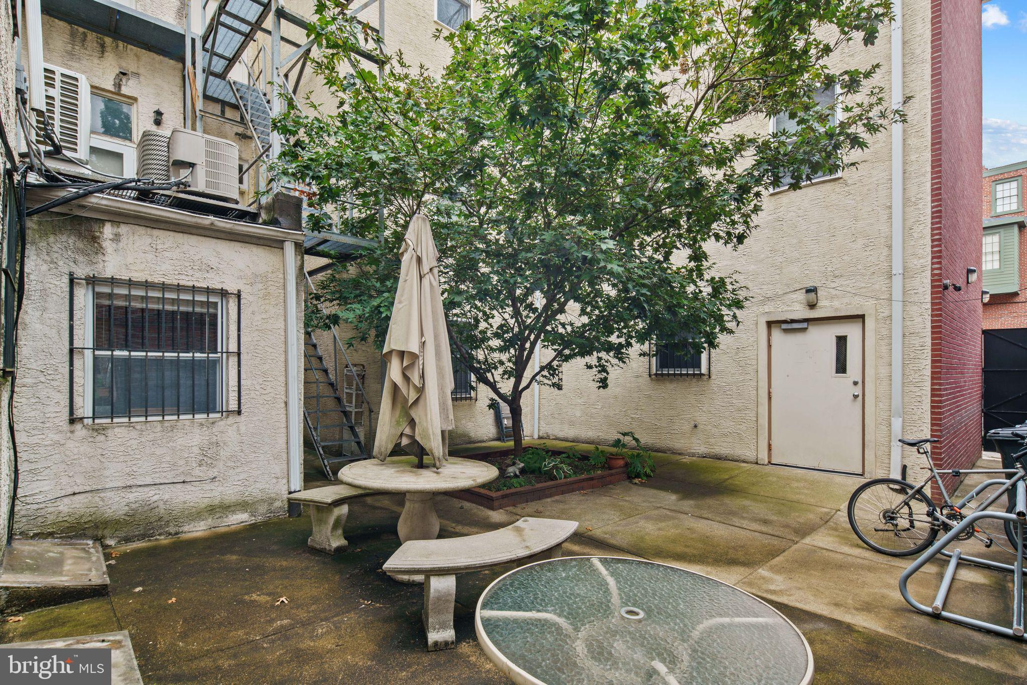 303 South 11th Street, Unit 9 Philadelphia, PA 19107 - Photo 33 of 36 a backyard of a house with fountain table and chairs