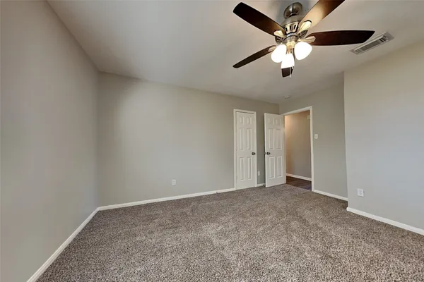 an empty room with chandelier fan