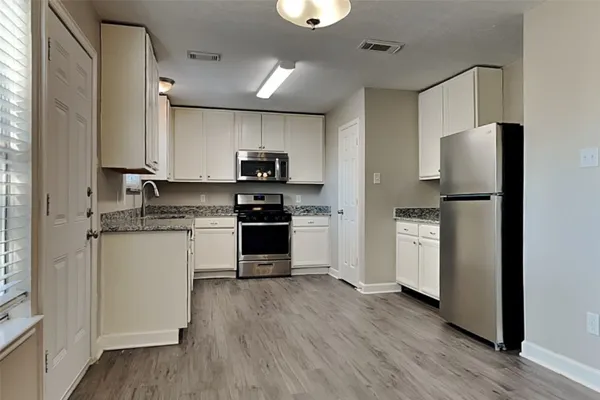 a kitchen with stainless steel appliances a refrigerator stove and microwave