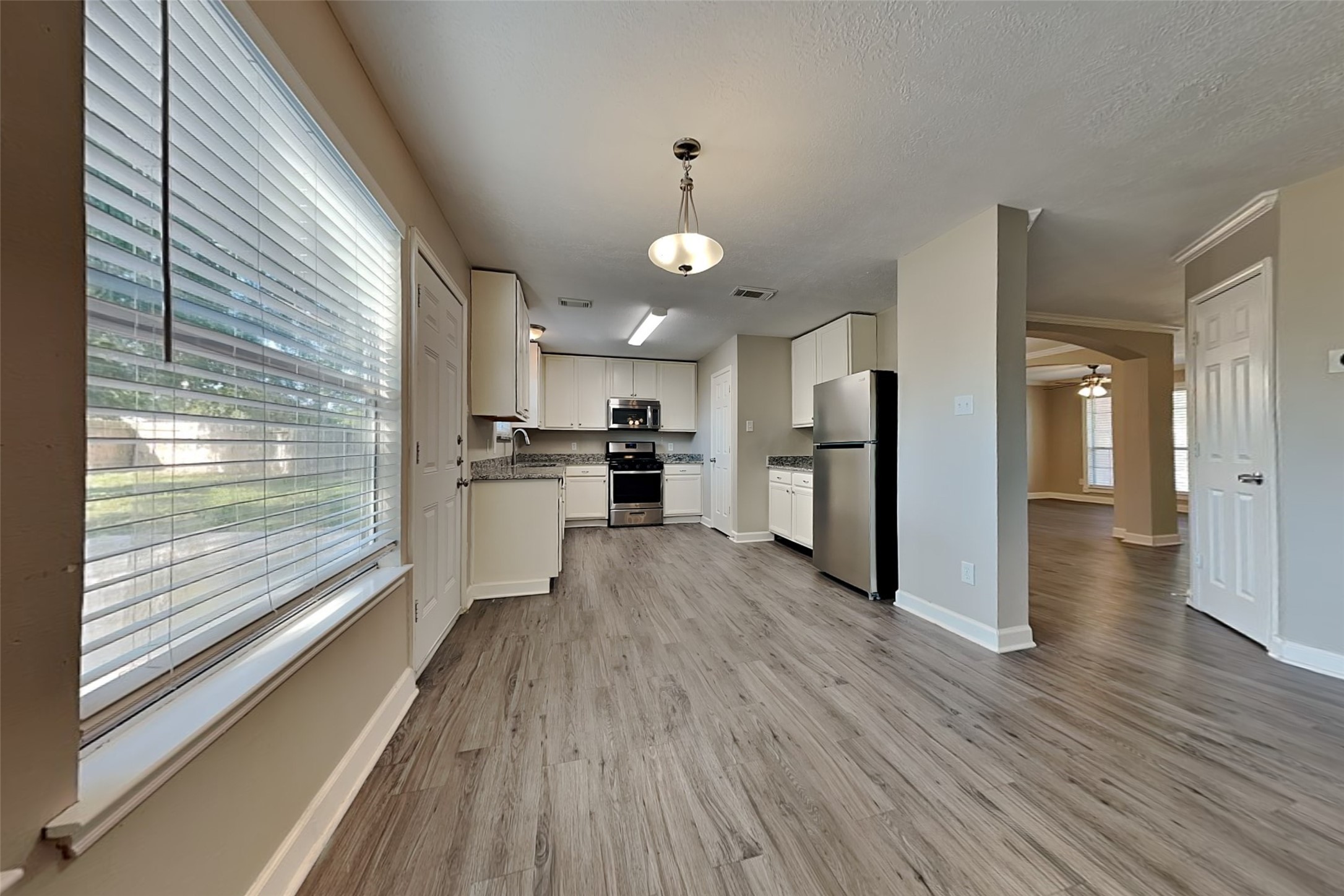 29439 Fox River Drive Spring, TX 77386 - Photo 8 of 29 a view of a kitchen with wooden floor a ceiling fan and windows