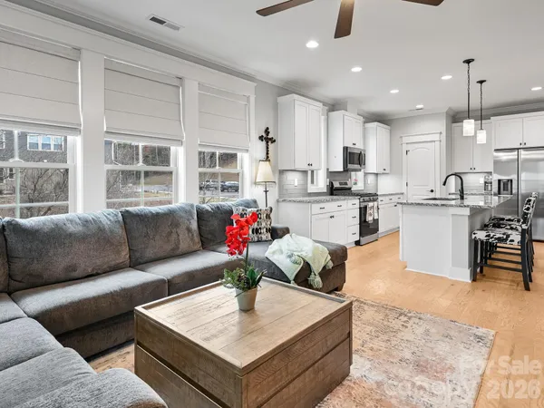 a living room with furniture and kitchen view