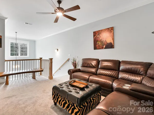 a living room with furniture a ceiling fan and a window