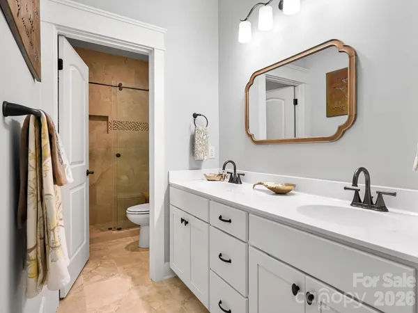 a bathroom with a double vanity sink mirror and toilet