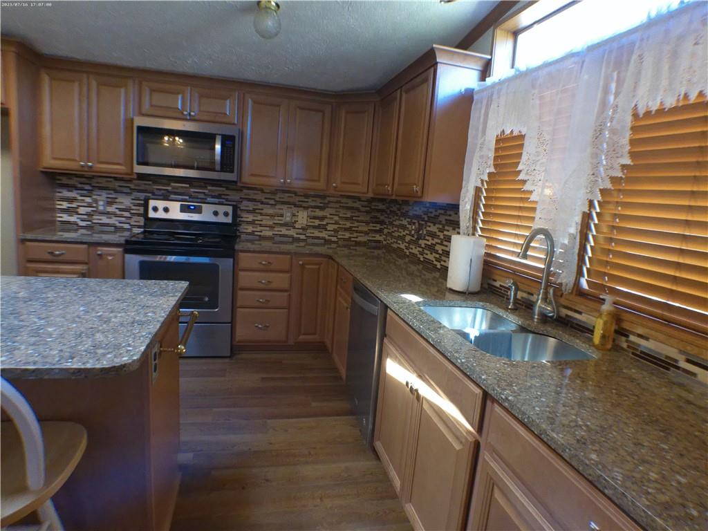 107 Hunting Hill Road Dilliner, PA 15327 - Photo 20 of 24 a kitchen with granite countertop a stove a sink and a microwave