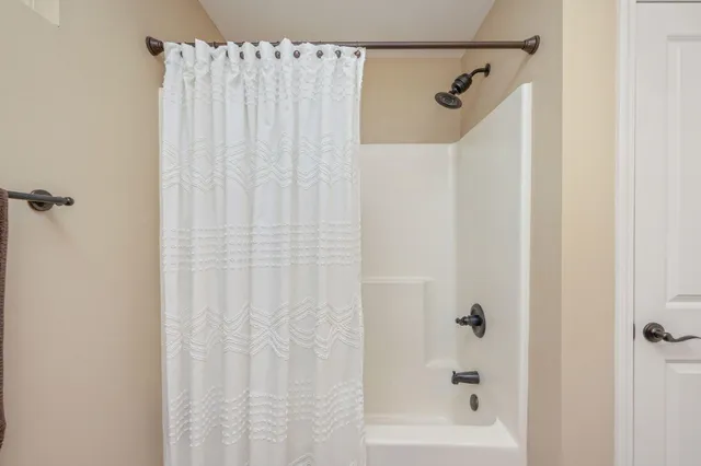 a bathroom with a shower and a bath tub