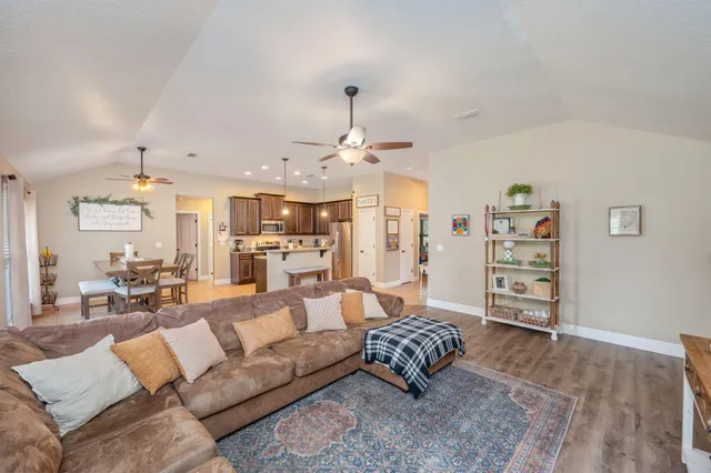 a living room with furniture a rug and kitchen view