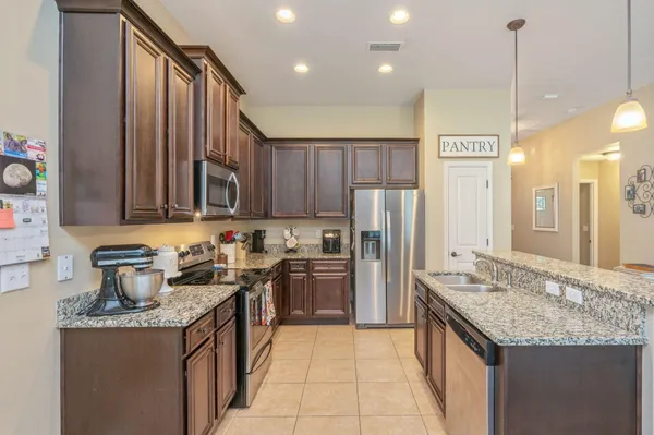 a kitchen with stainless steel appliances granite countertop a sink stove and refrigerator