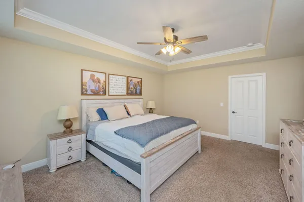 a spacious bedroom with a bed and a ceiling fan