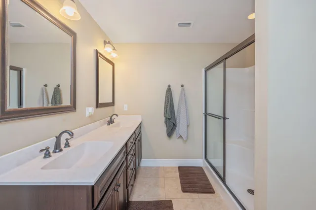 a bathroom with a double vanity sink and mirror