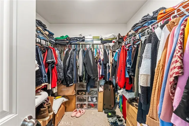 a view of walk in closet with clothes